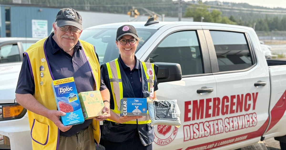 Two people stand by an emergency disaster services truck